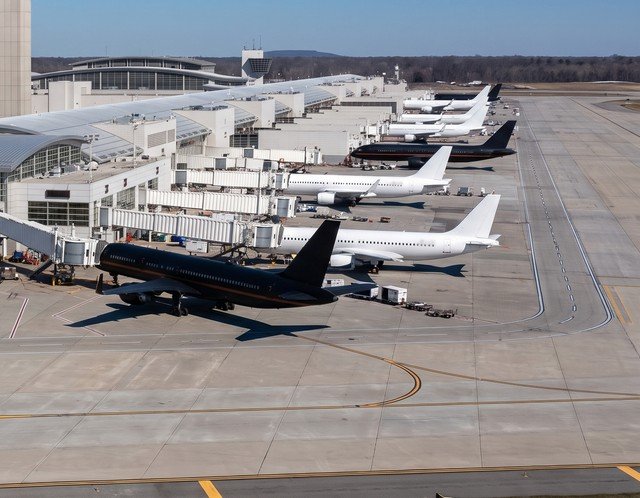 A row of parked aircraft beside a taxiway in clear daylight - illustrative context