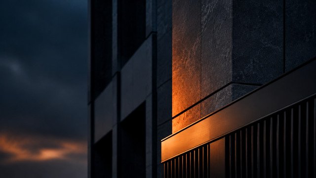 A dark tower facade catching the last orange light at dusk - illustrative context